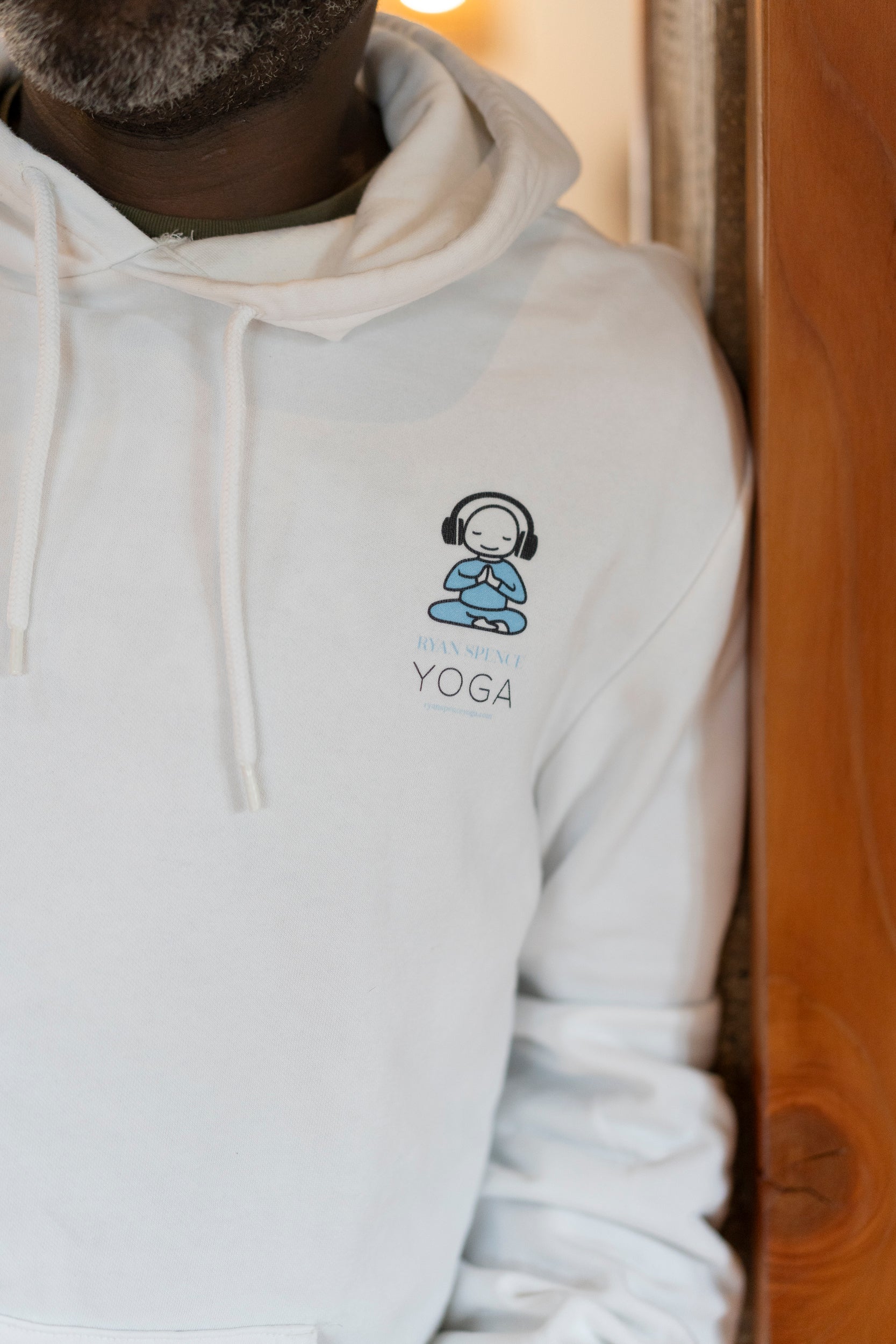 White hoodie with a yoga-themed design on a wooden surface